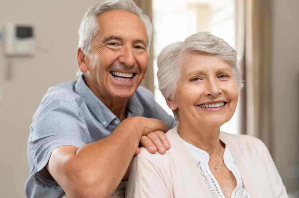 Happy senior couple smiling with dental implants